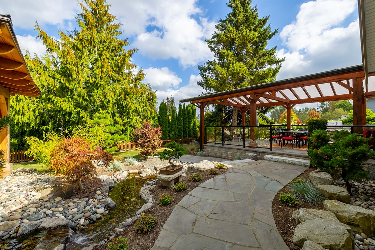 A natural, flagstone walkway leads guests from the large covered patio through the beautiful, Asian-inspired garden.